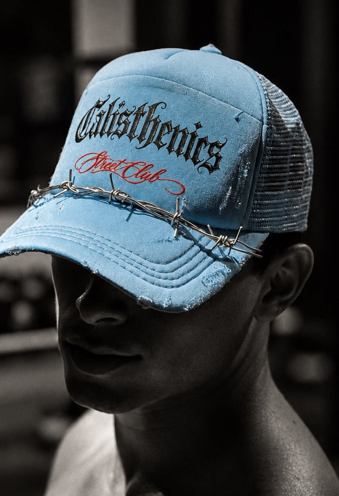 Street Club editorial: modelo con gorra azul cielo y estética monocromática